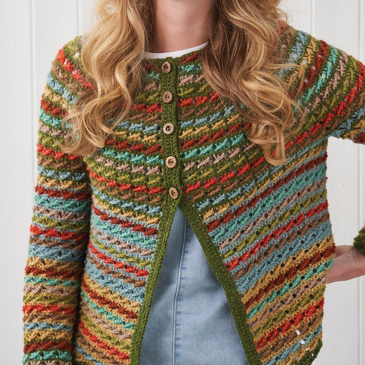 Multicolored striped cardigan worn by a person with a white background