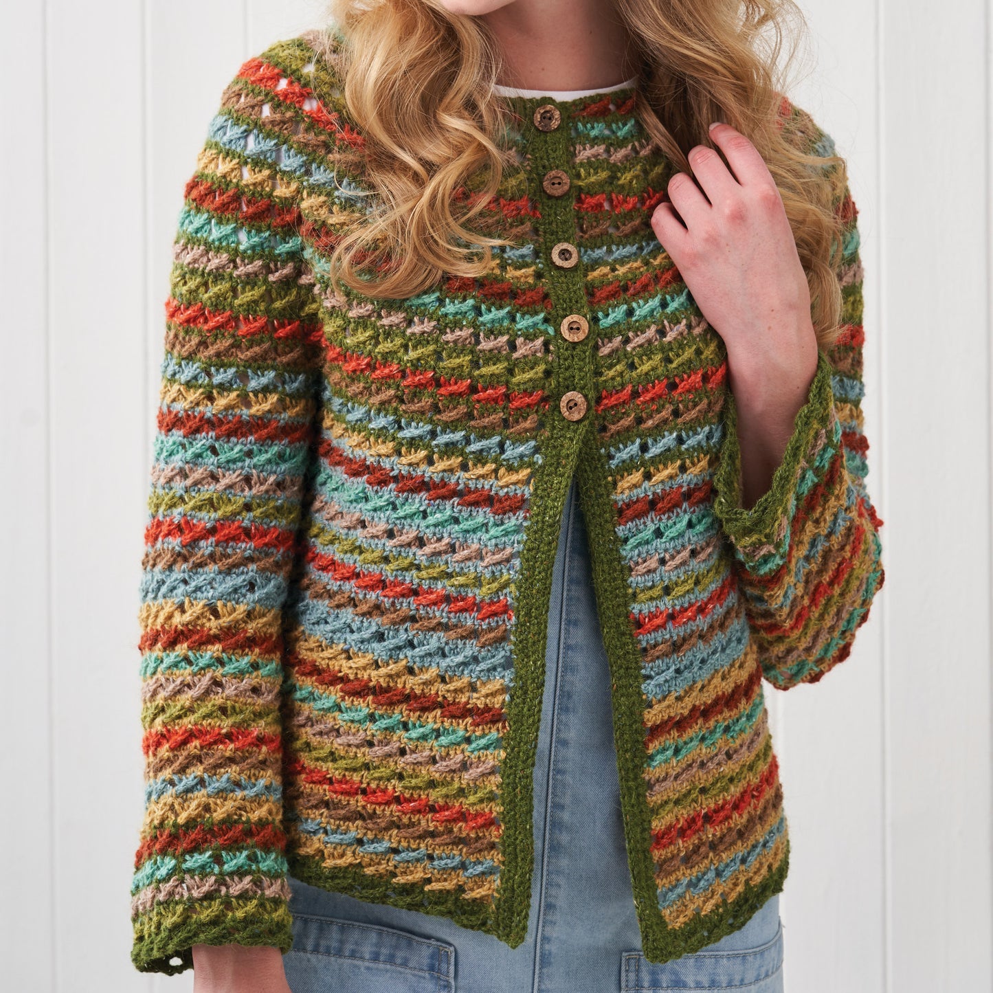 Colorful knitted cardigan worn by a person on a white background