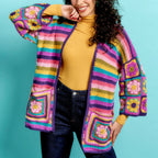 Woman wearing a colorful crochet cardigan against a blue background