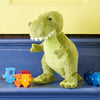 Plush dinosaur toy with number blocks on a blue surface against a yellow wall