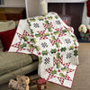 Decorative quilt with geometric pattern draped over a sofa in a cozy living room.