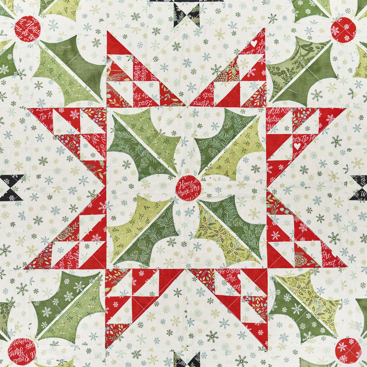 Quilt pattern with red, green, and white stars and geometric shapes.