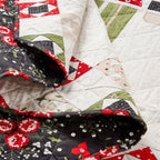 Close-up of a quilt with floral and geometric patterns in red, green, and white.