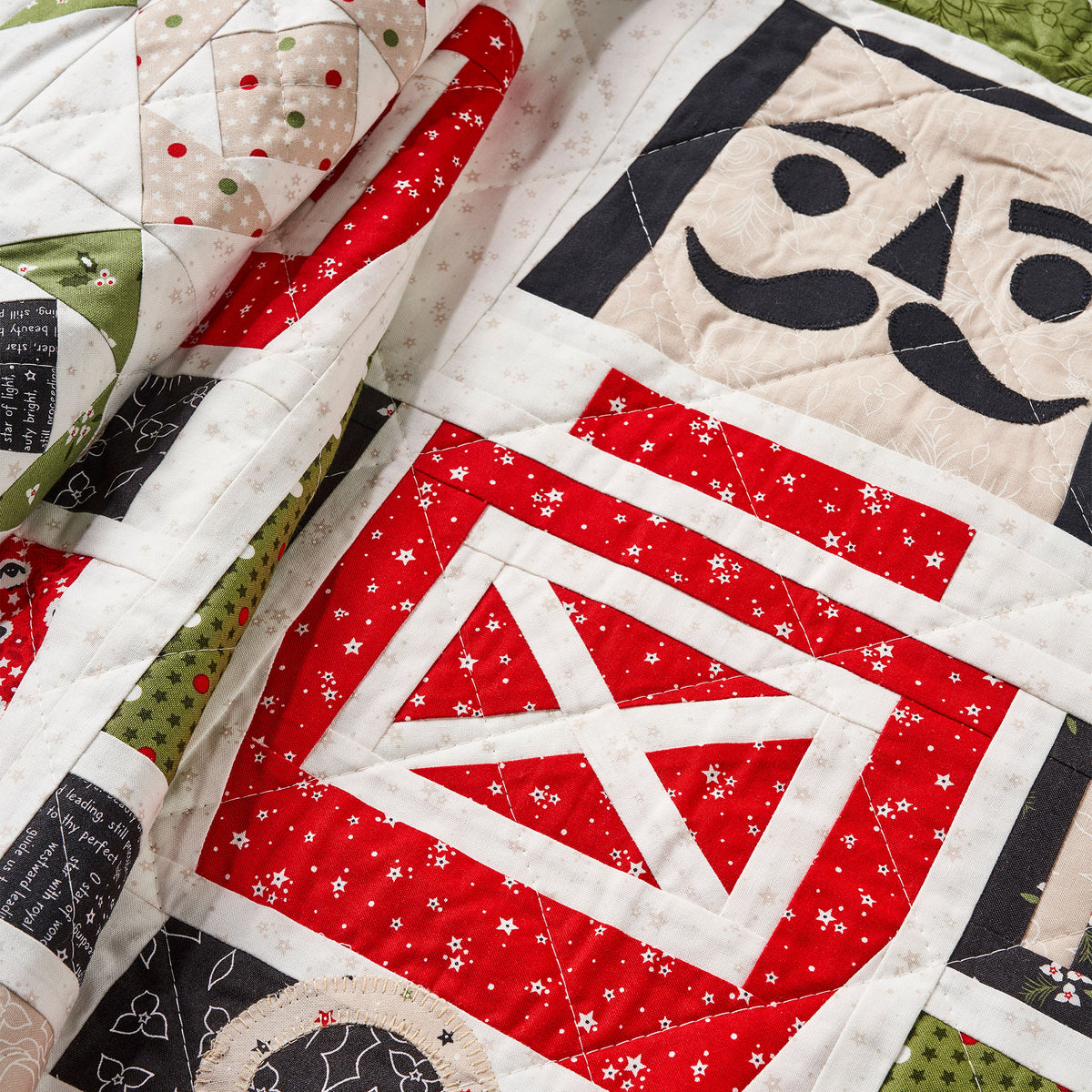 Quilt with geometric patterns featuring red, black, and white colors.
