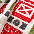 Close-up of a quilt with red, black, and white patterns