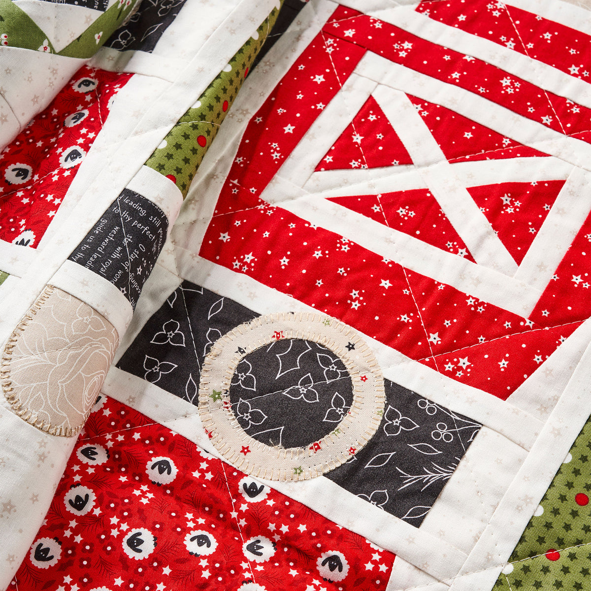 Close-up of a quilt with red, black, and white patterns