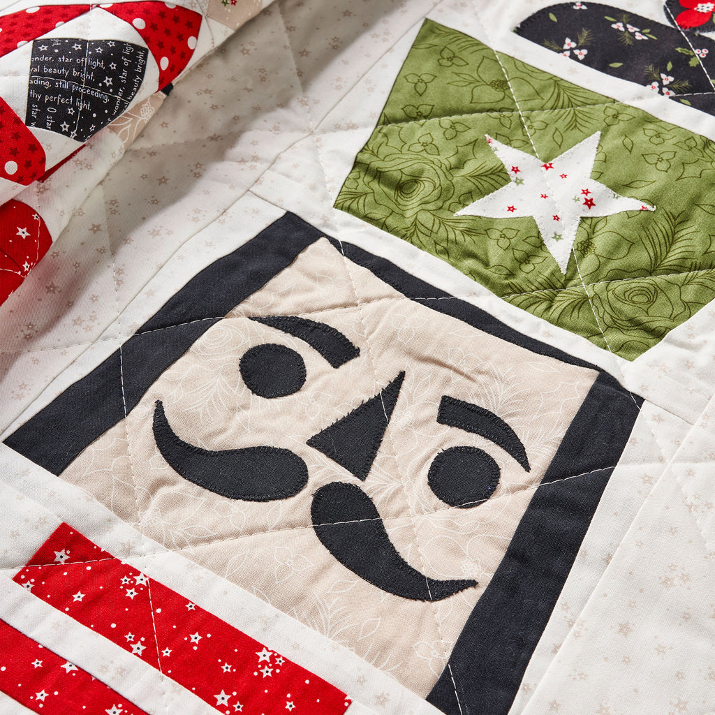 Close-up of a quilt with various patterns including stars and geometric shapes.