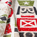 Quilt with patchwork design featuring red, white, and green colors.