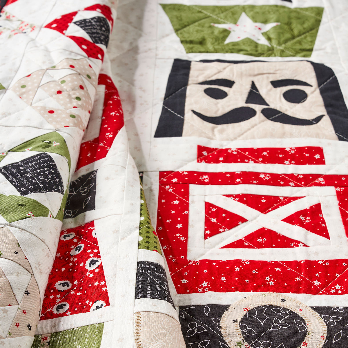 Quilt with patchwork design featuring red, white, and green colors.