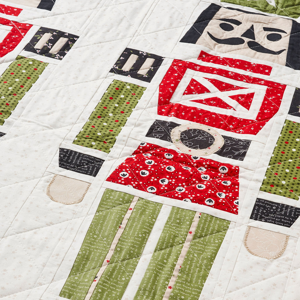 Quilt with robot design featuring red, green, and black patterns on a white background