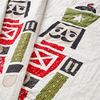 Quilt with robot-themed blocks in red, green, and black on a white background