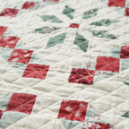 Close-up of a quilt with red, green, and white diamond patterns