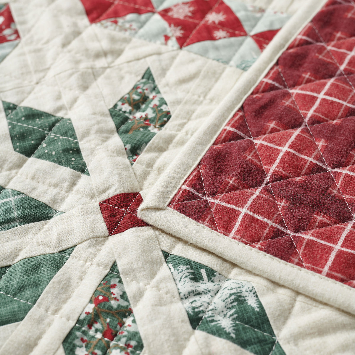 Close-up of a quilt with Christmas-themed fabric pieces.