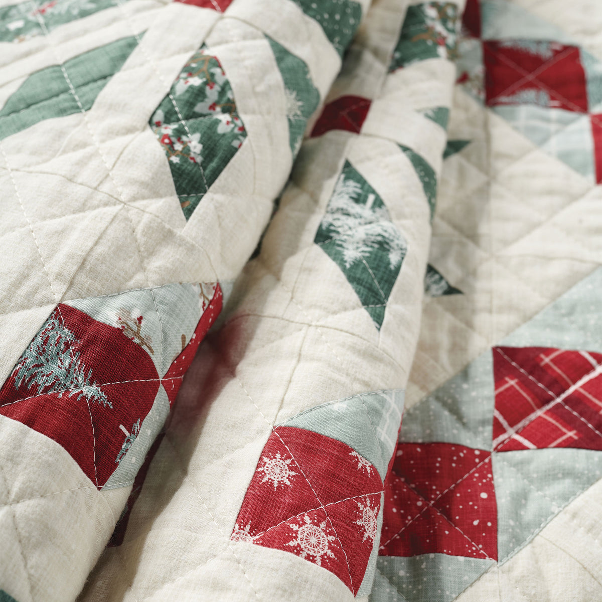 Close-up of a quilt with red, green, and white geometric patterns