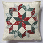 Quilted pillow with a geometric pattern in red, green, and white on a light background
