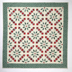 Quilt with red and green geometric pattern on a white background