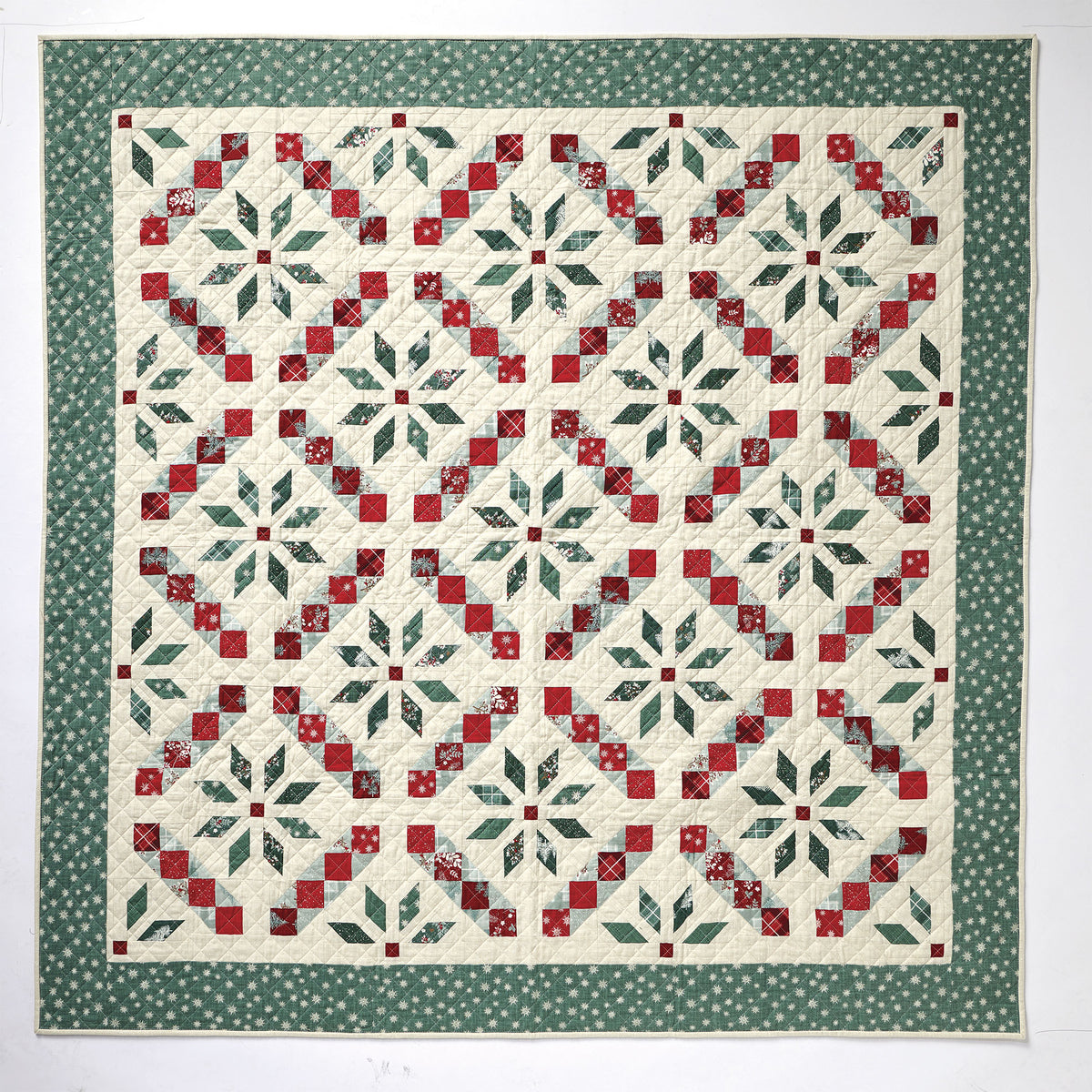 Quilt with red and green geometric pattern on a white background