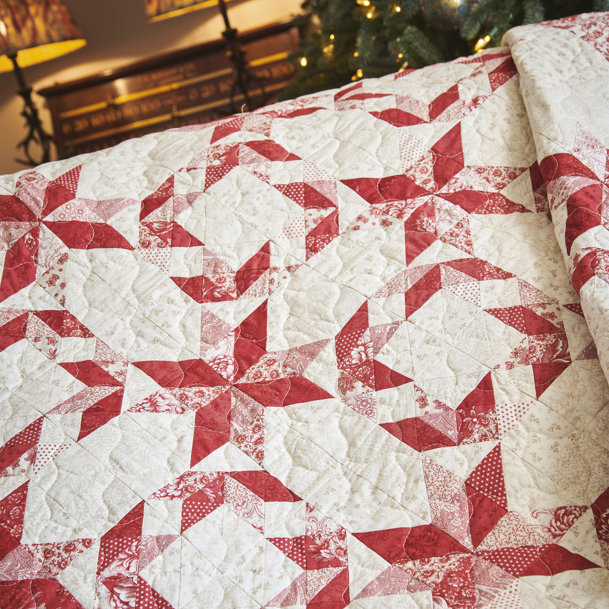 Red and white quilt with star pattern on a table