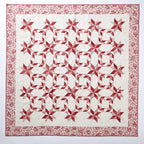 Quilt with red and white star pattern on a white background