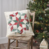 Decorative pillow with a Christmas pattern on a wooden chair in front of a decorated Christmas tree.