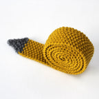 A rolled up yellow skinny knitted tie