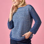 Woman wearing a blue and white patterned sweater against a pink background