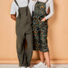 Two people wearing overalls against a beige background