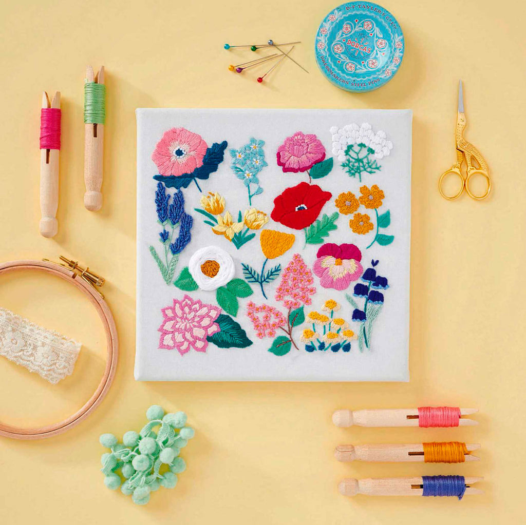embroidered flowers surrounded by embroidery tools