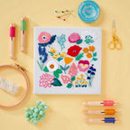 embroidered flowers surrounded by embroidery tools