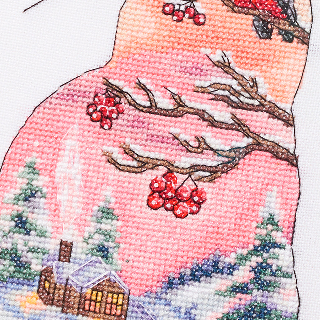 Cross-stitched design of a pink cat with red berries and a snowy landscape.