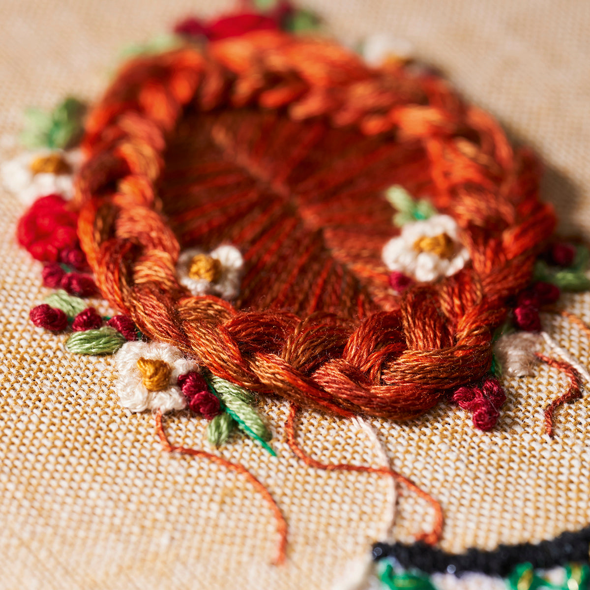 Embroidered design of a heart with braided texture on fabric