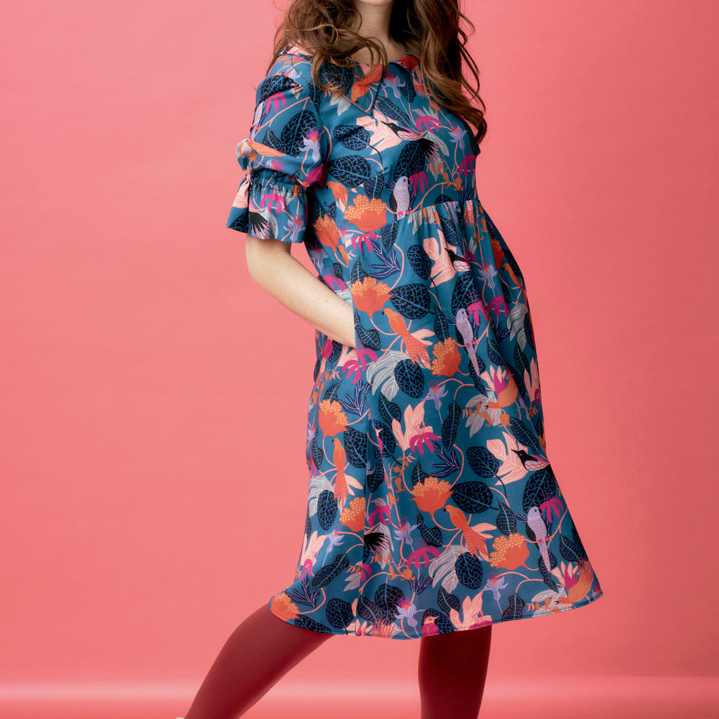 Woman wearing a floral dress against a pink background