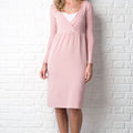 Pink dress worn by a person against a white brick wall