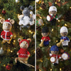 Knitted Christmas mice and traditional musician ornaments on a Christmas tree with lights and pinecones.