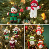 Christmas tree decoration knitting patterns including Christmas elves, angels and snowmen. These are shown hanging on a lit Christmas tree