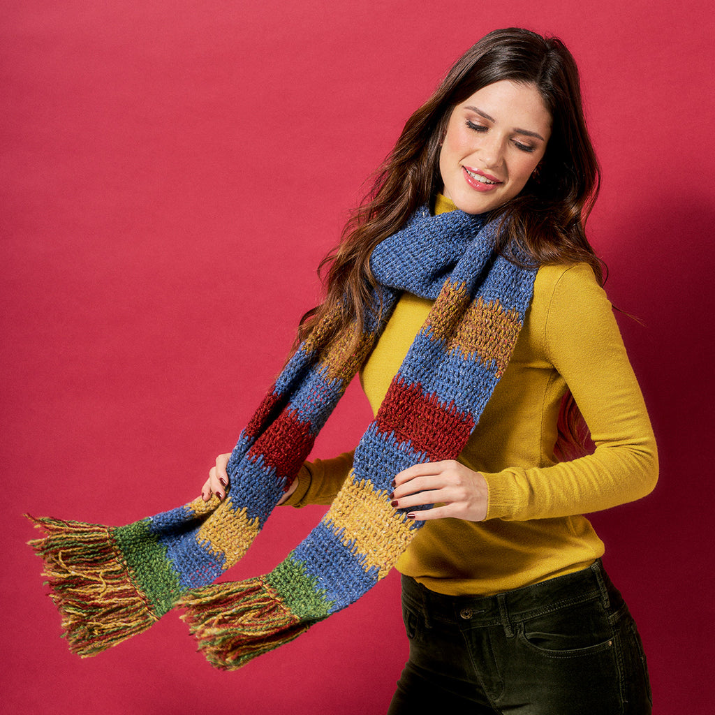 Woman wearing a colorful striped scarf against a red background