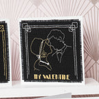 Embroidered card with a couple embracing and 'My Valentine' text on a geometric patterned background.