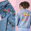 Denim jacket with floral embroidery on a pink background