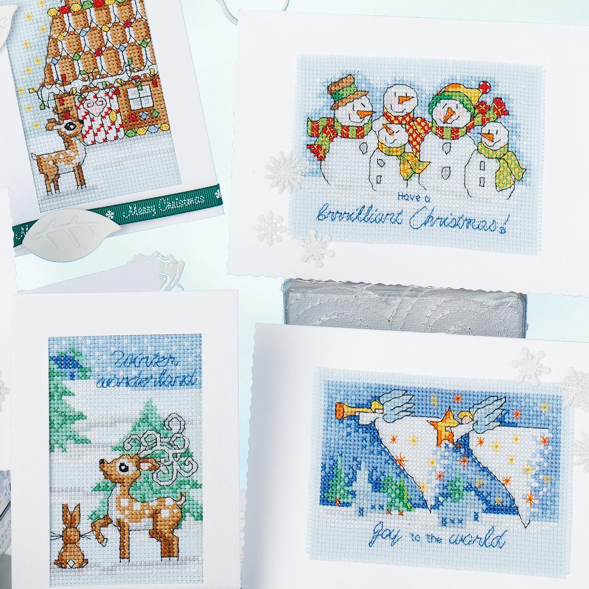 Collection of cross-stitched Christmas cards with festive designs on a white background.