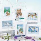 Collection of cross-stitched Christmas cards with various designs on a decorative stand.