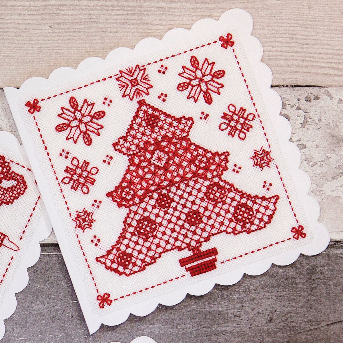 Decorative redwork cross stitch patterns on a wooden surface