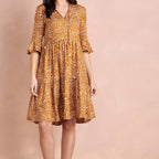 Woman wearing a patterned dress on a beige background