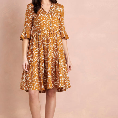 Woman wearing a patterned dress on a beige background