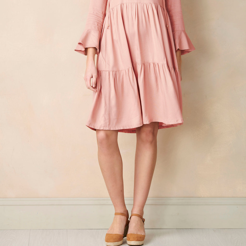 Pink dress worn by a person against a plain background