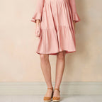 Pink dress worn by a person against a plain background