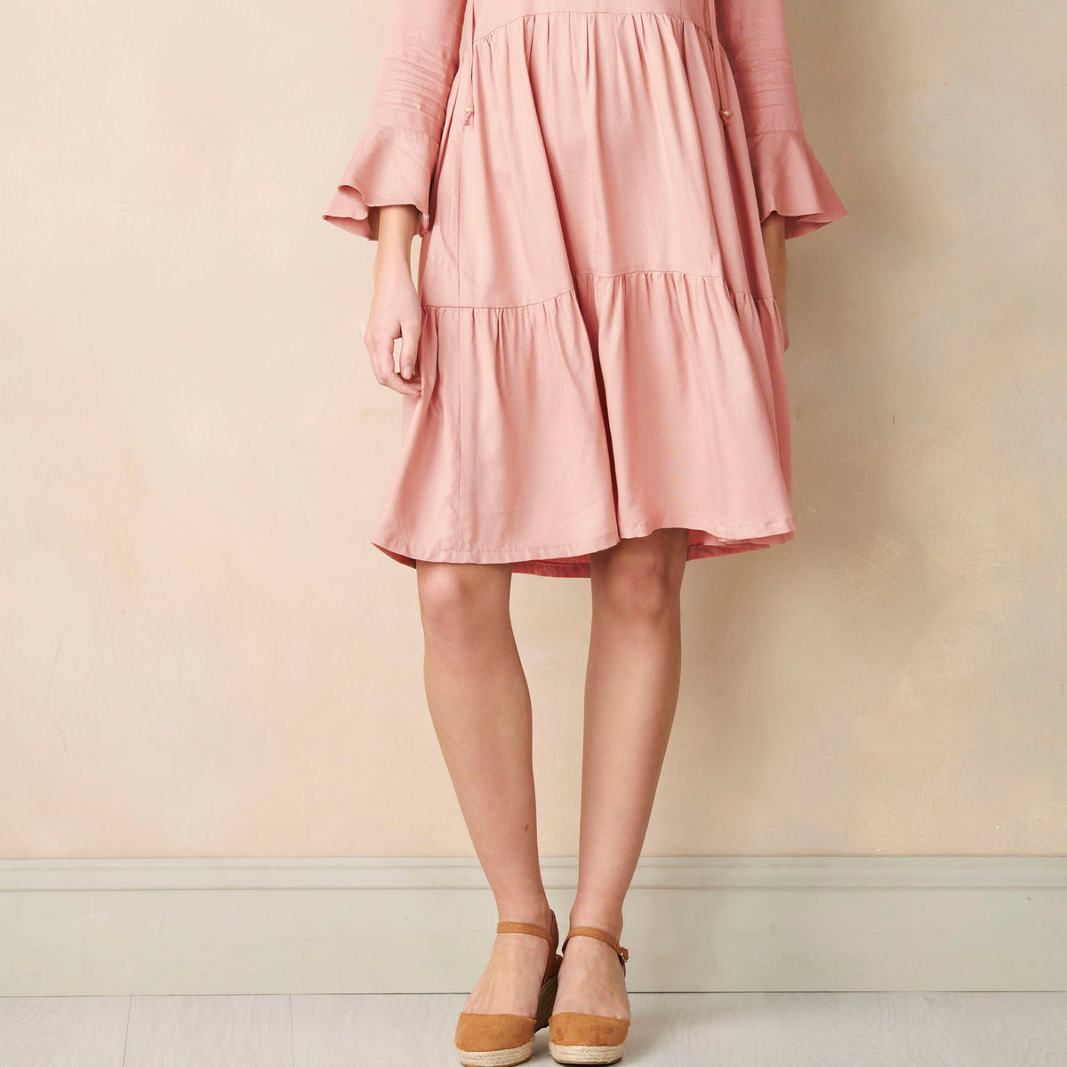 Pink dress worn by a person against a plain background