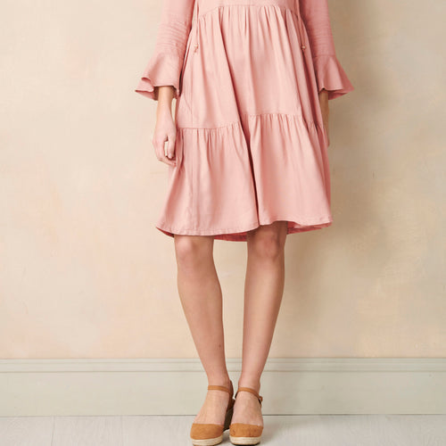 Pink dress worn by a person against a plain background