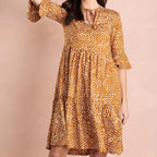 Woman wearing a patterned dress on a beige background