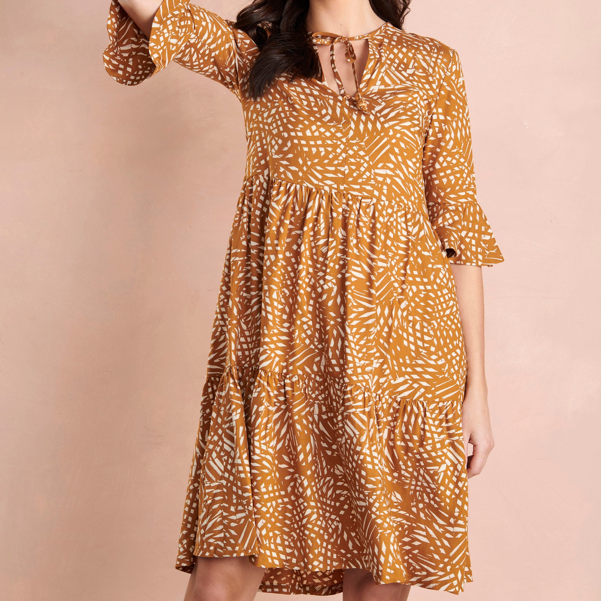 Woman wearing a patterned dress on a beige background