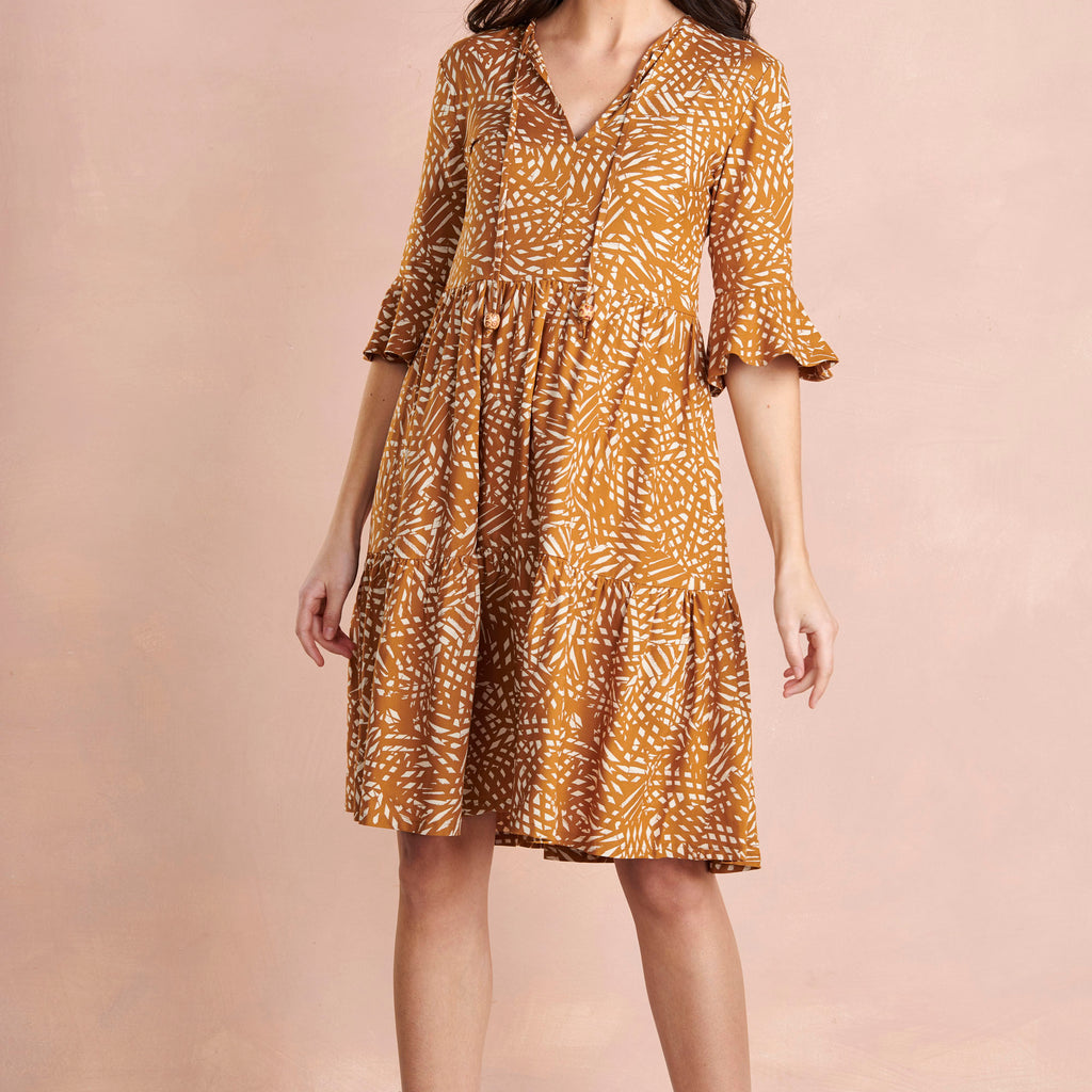 Woman wearing a patterned dress on a beige background